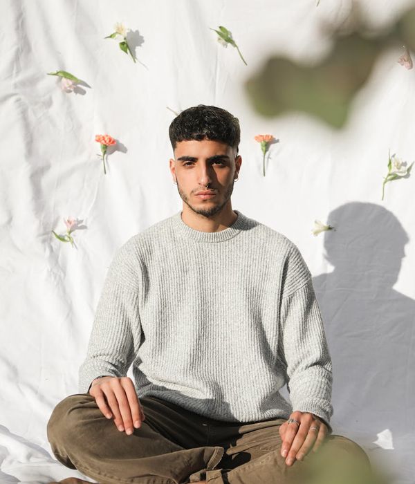 Man in a focused, calm pose against a dark, textured background.